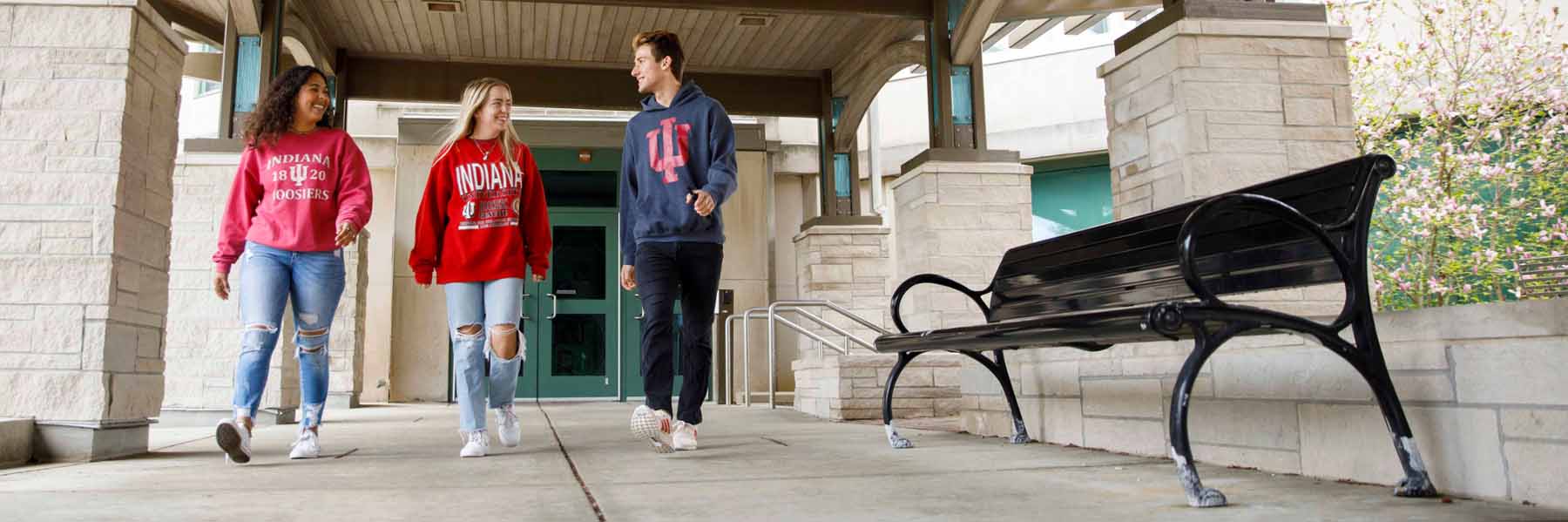 Three students walk outside in IU gear.