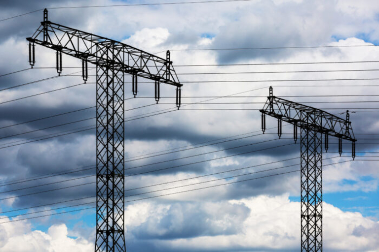 Power lines against a blue cloudy sky