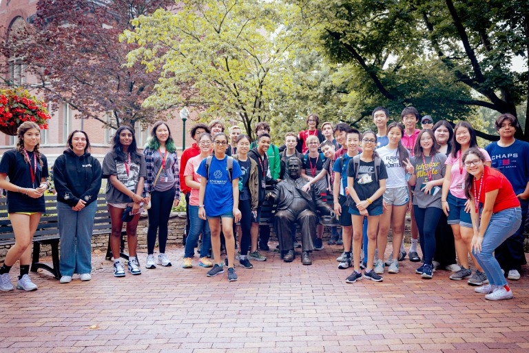 Large group of young students by the Wells statue