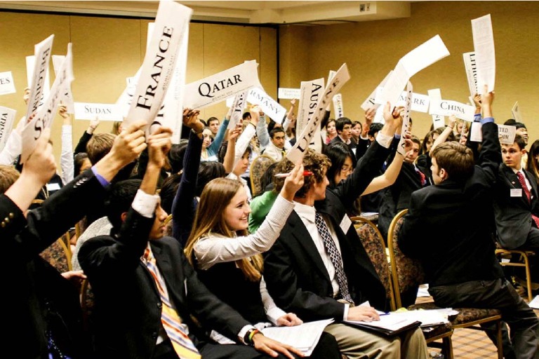 Delegates shake papers with their country names
