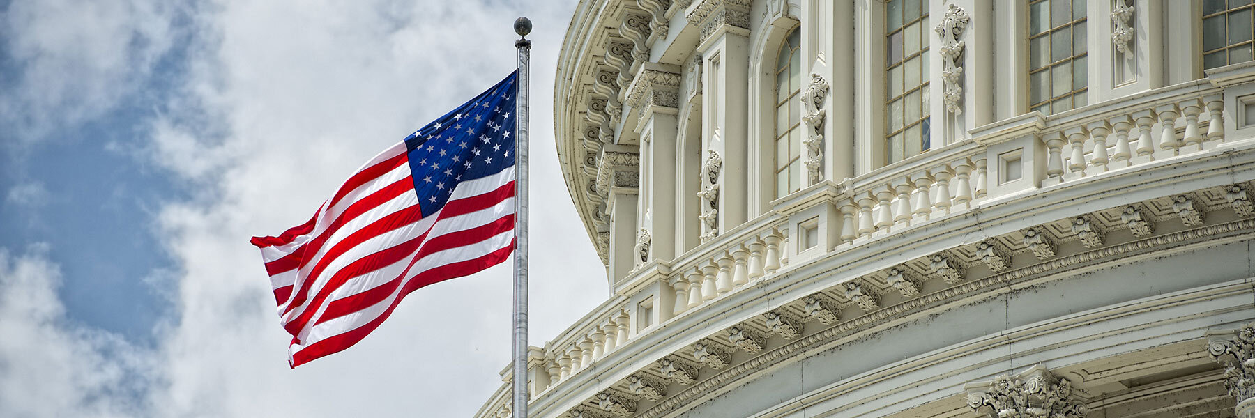 American flag waves in front of United States Capitol. 